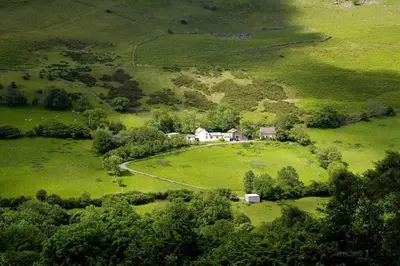 an aerial view of a house in a green field at The Castle, Capel-y-Ffin, The Black Mountains in Abergavenny
