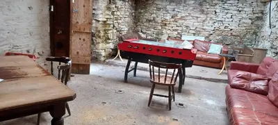 a living room with a red table and a couch at The Castle, Capel-y-Ffin, The Black Mountains in Abergavenny