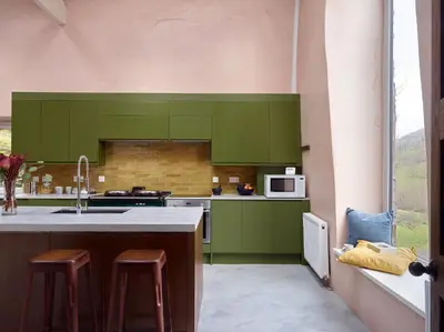 a kitchen with green cabinets and a sink at The Castle, Capel-y-Ffin, The Black Mountains in Abergavenny