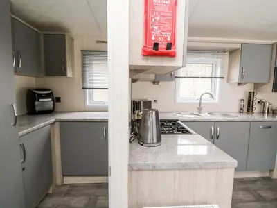a kitchen with gray cabinets and a counter top at The Hideout in Llanina