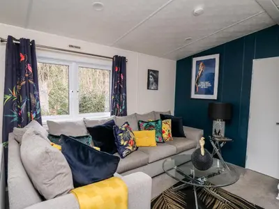 a living room with a gray couch with colorful pillows at The Hideout in Llanina