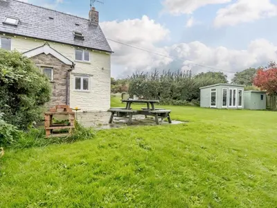 a picnic table in the yard of a cottage at 2 Bed in Brecon oc-51153 in Llandefalle