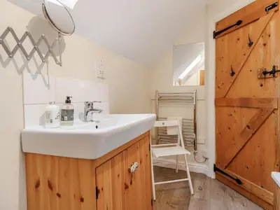 a bathroom with a sink and a wooden door at 2 Bed in Brecon oc-51153 in Llandefalle