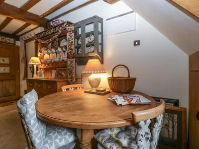 a dining room with a wooden table and chairs at Hoarders Cottage in Hereford