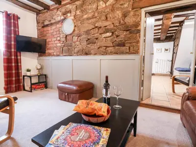 a living room with a brick wall and a table at The Brewhouse in Church Stretton