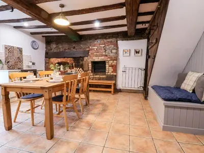 a dining room with a table and chairs and a couch at The Brewhouse in Church Stretton