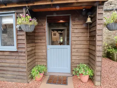 a house with a white door and two potted plants at The Brewhouse in Church Stretton