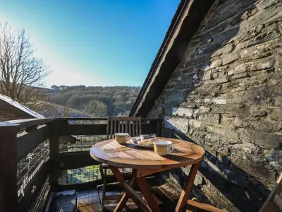 a wooden table on the balcony of a building at Y Cartws in Llanybydder