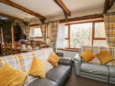 a living room with two couches and a table at Y Felin in Llanybydder