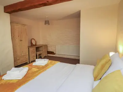 a bedroom with a large white bed and a desk at Y Felin in Llanybydder