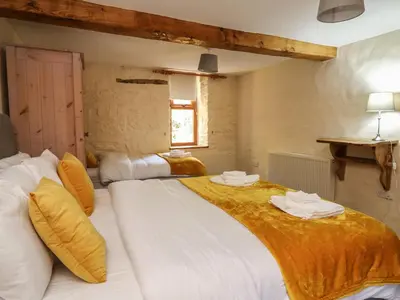 a bedroom with two beds with towels on them at Y Felin in Llanybydder