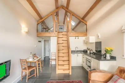 a loft conversions kitchen and living room with a ladder at Nant in Dyffryn