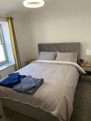 a bedroom with a bed with two towels on it at Aberystwyth maisonette flat in Aberystwyth