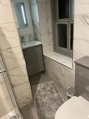 a bathroom with a toilet and a sink and a mirror at Aberystwyth maisonette flat in Aberystwyth