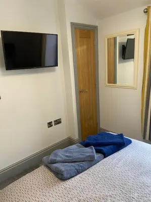 a bedroom with a bed with a flat screen tv on the wall at Aberystwyth maisonette flat in Aberystwyth