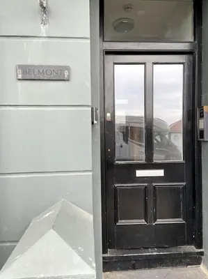a black door with a sign in front of it at Aberystwyth maisonette flat in Aberystwyth