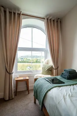 a bedroom with a bed and a large window at The Cedars in Builth Wells
