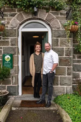 a man and a woman standing in front of a door at The Cedars in Builth Wells