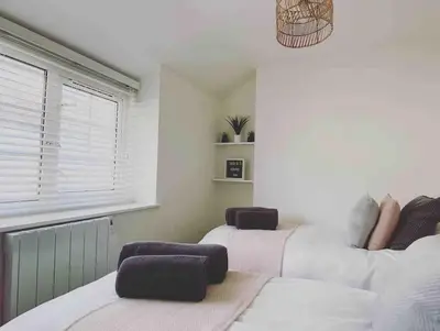 a bedroom with two beds and a window at Cosy Cottage in Aberaeron