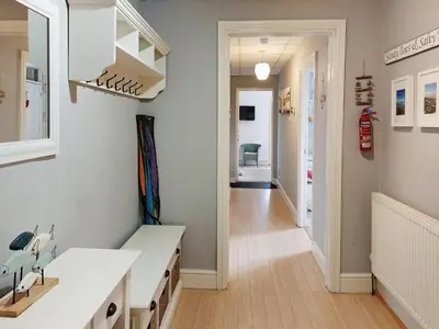 a kitchen with a white counter and a hallway at Beach Front Apartment in Tywyn in Tywyn