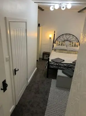 a room with a bedroom with a bed and a door at Dolgoch Mill House Annexe in Llanfair Caereinion
