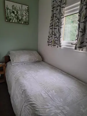 a small bedroom with a bed and a window at Bunny Lodge 30 - Riverside in Builth Wells