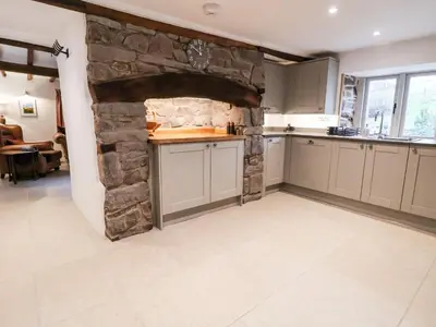 a kitchen with a stone fireplace in the middle at Rockhill Farmhouse in Craven Arms