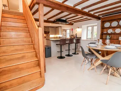 a kitchen and dining room with a table and chairs at Rockhill Farmhouse in Craven Arms