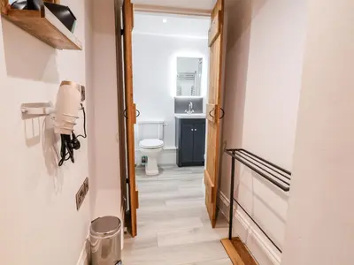 a hallway leading to a bathroom with a toilet at Rockhill Farmhouse in Craven Arms