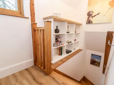 a staircase with a book shelf in a room at Rockhill Farm Hay Barn in Craven Arms