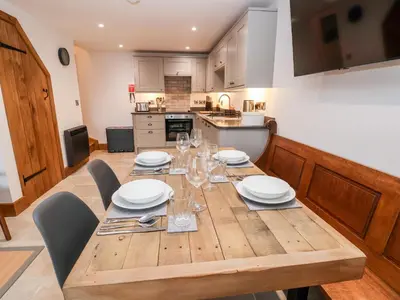 a wooden table with plates and glasses on it in a kitchen at Rockhill Farm Hay Barn in Craven Arms