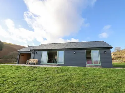 a house with a green lawn in front of it at Dol Blodau in Llandrindod Wells