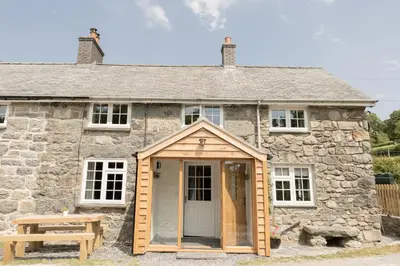 a building with a door and a picnic table in front of it at Afonfa - Llanuwchllyn in Bala