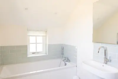 a bathroom with a sink and a bath tub and a window at Afonfa - Llanuwchllyn in Bala