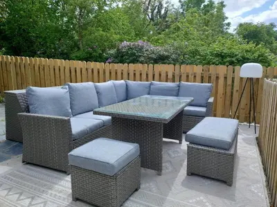 a patio with a couch and a table and chairs at Afonfa - Llanuwchllyn in Bala