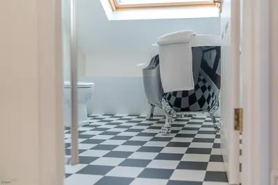 a bathroom with a black and white checkered floor at Brynhoreb in Aberdyfi