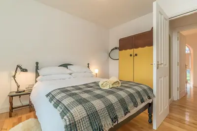 a bedroom with a bed with a plaid blanket at Brynhoreb in Aberdyfi