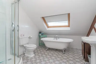 a bathroom with a tub and a toilet and a sink at Brynhoreb in Aberdyfi