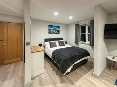 a bedroom with a large bed and a television at The Annexe in Guilsfield