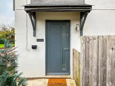 a blue door on a white house with a fence at The Annexe in Guilsfield