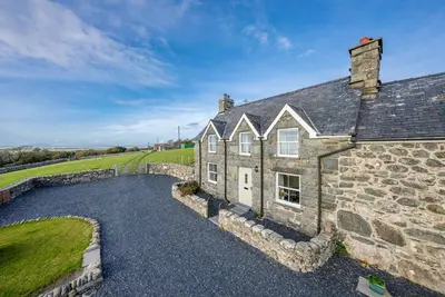 an old stone house with a stone wall at Ty-Newydd-Frongaled in Dyffryn