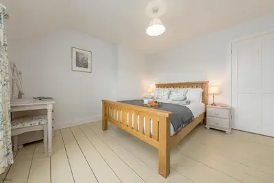 a bedroom with a bed and a nightstand and a table at Ty-Newydd-Frongaled in Dyffryn