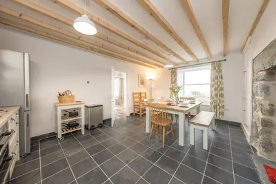 a kitchen and dining room with a table and chairs at Ty-Newydd-Frongaled in Dyffryn