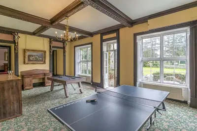 a living room with a ping pong table and windows at Gors-Y-Gedol in Dyffryn