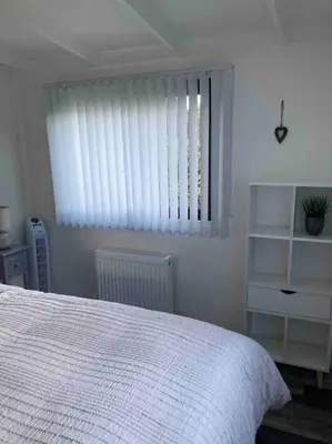 a bedroom with a white bed and a window at 7F Cwtch Cymru Lodge, Caer Beris Holiday Park - no commercial vehicles permitted on site in Builth Wells