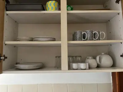a kitchen shelf with plates and cups and dishes at King room - PenrhynCoch - Aberystwyth in Aberystwyth