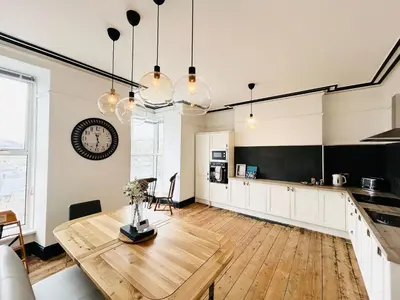 a kitchen and dining room with a wooden table at Mountain View Home - Dolgellau in Dolgellau