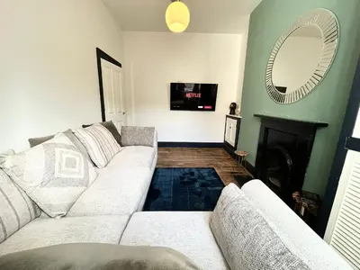 a living room with a white couch and a mirror at Mountain View Home - Dolgellau in Dolgellau