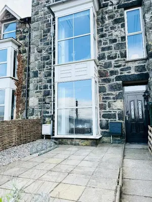 a brick house with a large window and a door at Mountain View Home - Dolgellau in Dolgellau