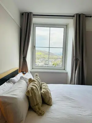 a bedroom with a bed with a large window at Dolgellau Grand Heights Apt in Dolgellau